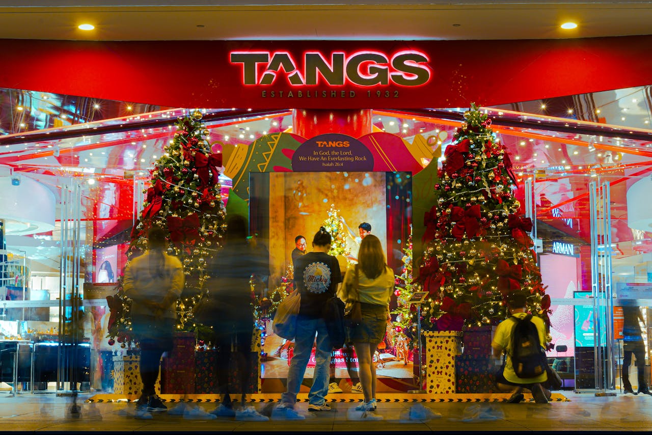 A vibrant Christmas display with lights and decorations at TANGS storefront, capturing holiday spirit.