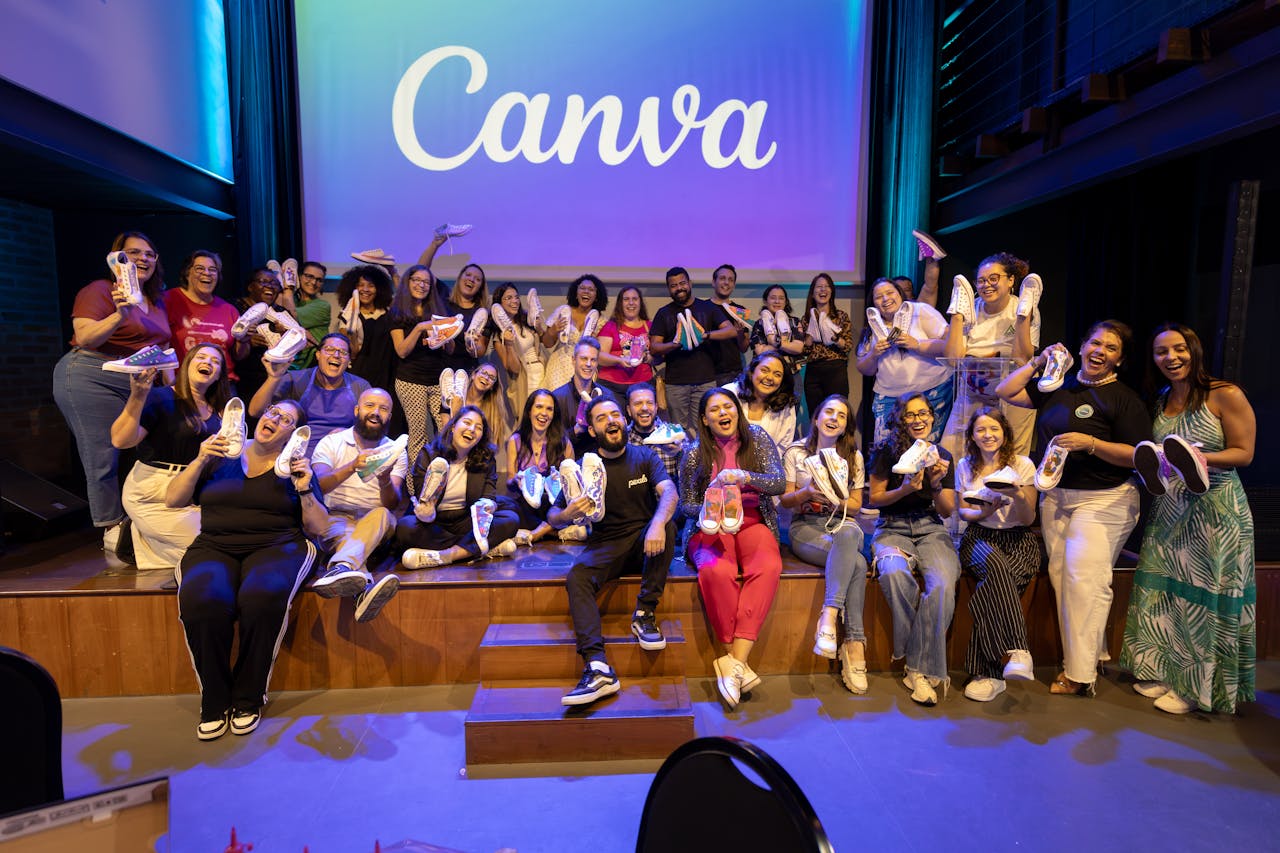 Large group celebrating with custom sneakers at a Canva event.