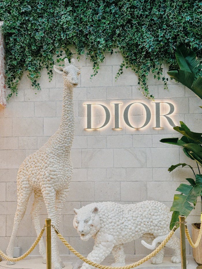 Intricately designed white animal sculptures at a Dior display.